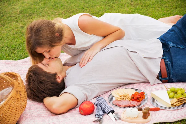 Привлекательная пара на романтическом послеобеденном пикнике целуется — стоковое фото