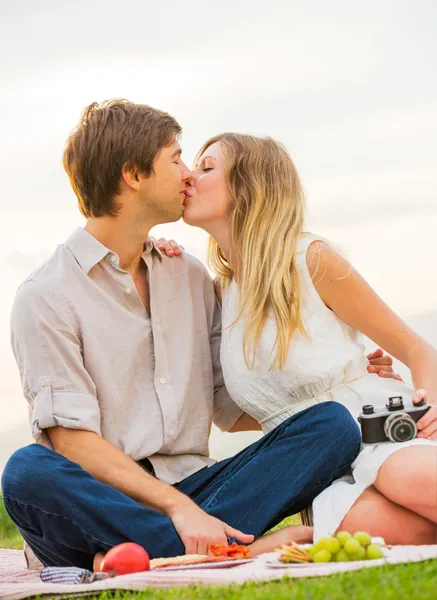 Attractive couple on romantic afternoon picnic kissing — Stock Photo, Image