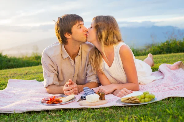 Atrakcyjna para całuje na romantyczny piknik — Zdjęcie stockowe