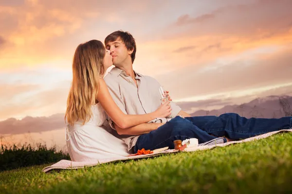 Attraktives Paar küsst sich auf romantischem Picknick — Stockfoto