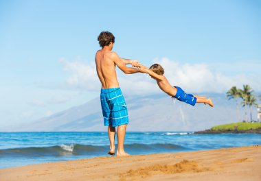 mutlu baba ve oğul birlikte kumsalda oynarken