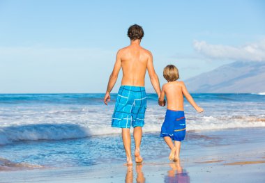 mutlu baba ve oğul birlikte sahilde yürüyüş