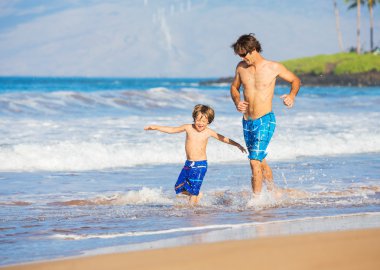 mutlu baba ve oğul birlikte sahilde yürüyüş