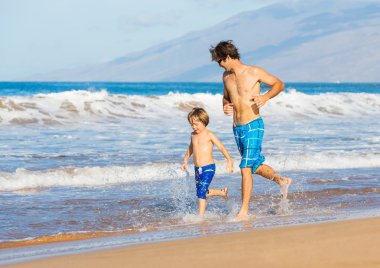mutlu baba ve oğul birlikte sahilde yürüyüş