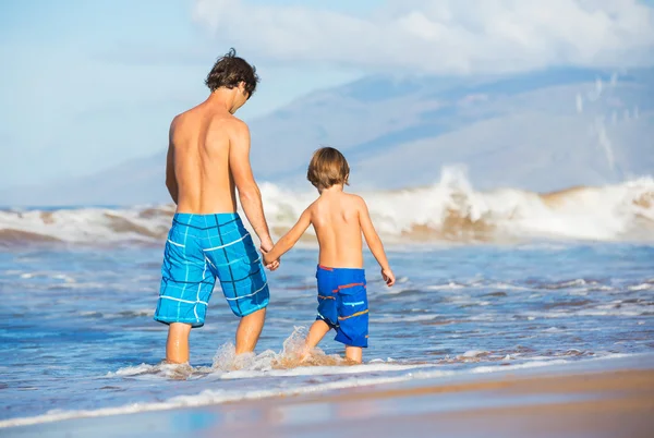 Счастливый отец и сын, гуляющие вместе на пляже — стоковое фото