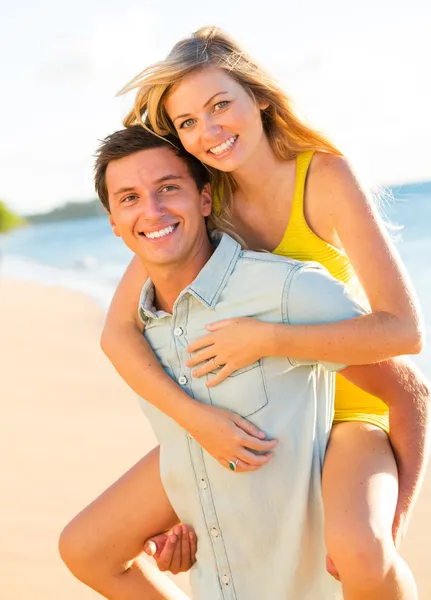 Aantrekkelijke paar spelen op het strand bij zonsondergang — Stockfoto