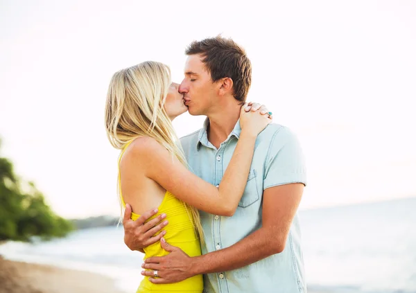 日落时分在海滩上接吻的情侣 — 图库照片