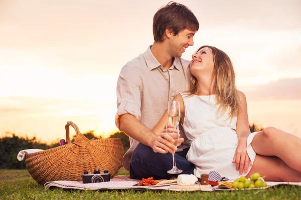 Пара наслаждается романтическим закатом пикник — стоковое фото