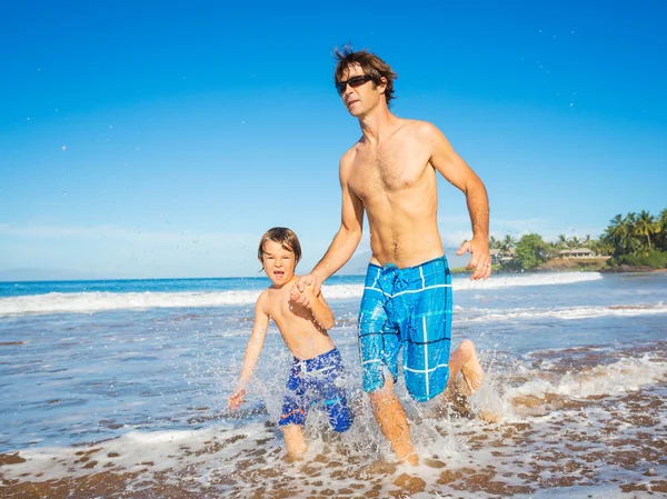 Happy father and son walking together at beach — Stock Photo, Image