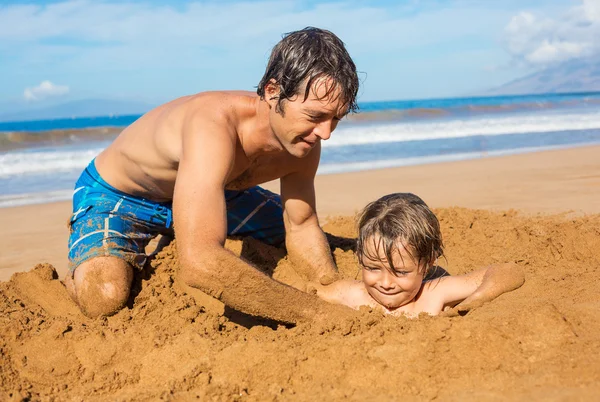 Father and son playing together in the sand on tropical beach — Stock Photo, Image