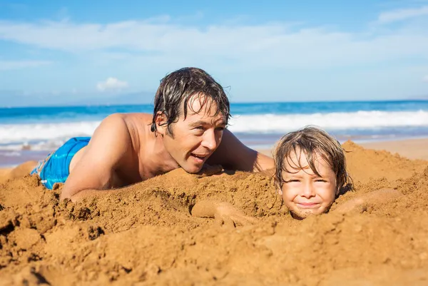 Vader en zoon spelen samen in het zand op tropisch strand — Stockfoto