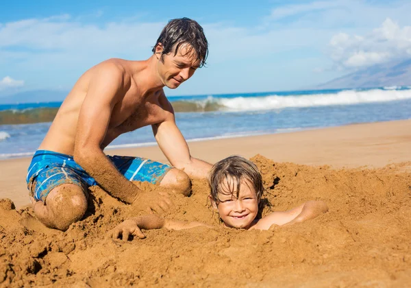 Padre e figlio giocano insieme nella sabbia sulla spiaggia tropicale — Foto Stock