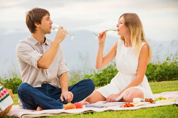 Пара наслаждается романтическим закатом пикник Лицензионные Стоковые Фото
