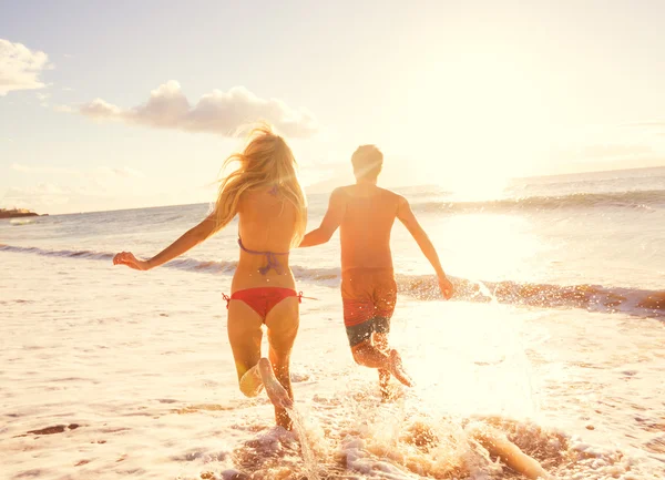 Casal desfrutando do pôr do sol na praia — Fotografia de Stock