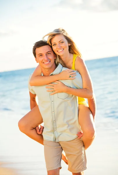 Casal desfrutando do pôr do sol na praia — Fotografia de Stock