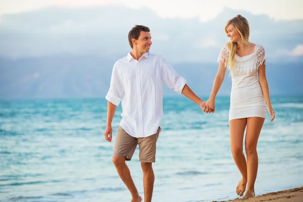 Casal desfrutando do pôr do sol na praia — Fotografia de Stock