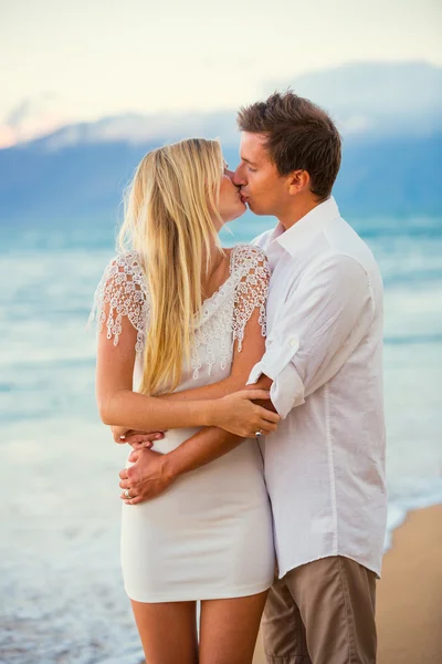 Paar genieten van de zonsondergang op het strand — Stockfoto