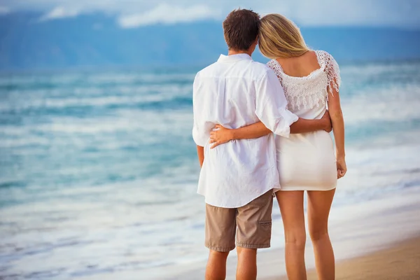 Пара, наслаждающаяся закатом на пляже — стоковое фото