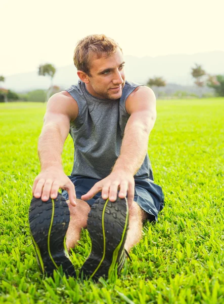 Ung man stretching före träningen — Stockfoto