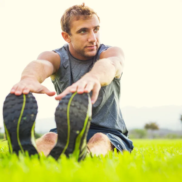 Young man stretching before exercise — Stock Photo, Image