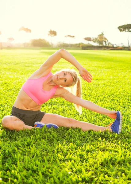 Mujer joven estirándose antes del ejercicio —  Fotos de Stock