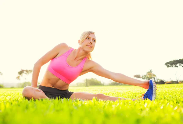 Mujer joven estirándose antes del ejercicio —  Fotos de Stock