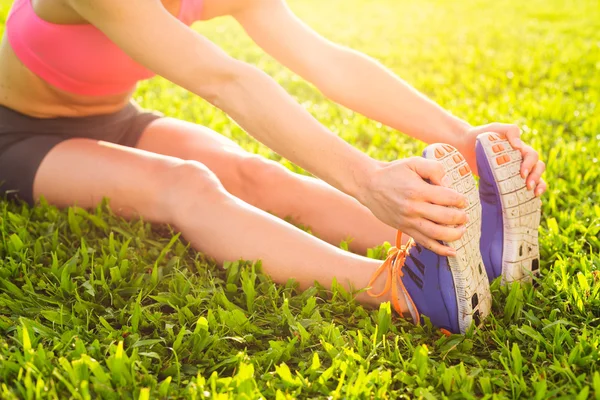 Aantrekkelijke fit jonge vrouw die zich uitstrekt — Stockfoto