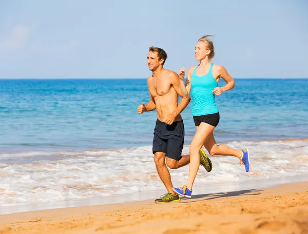 Paar rennen op het strand — Stockfoto