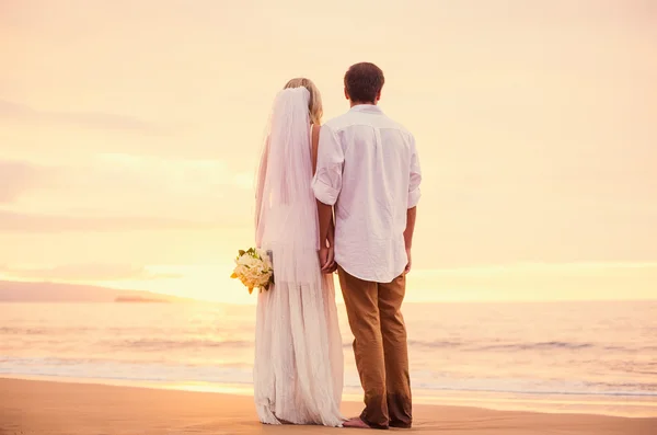 Sposa e sposo sulla spiaggia al tramonto — Foto Stock