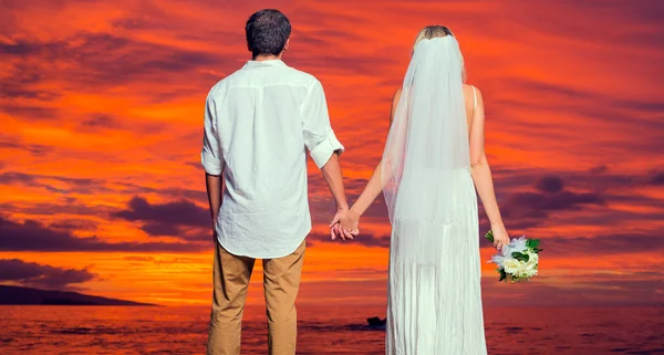 Bride and groom on beach at sunset — Stock Photo, Image