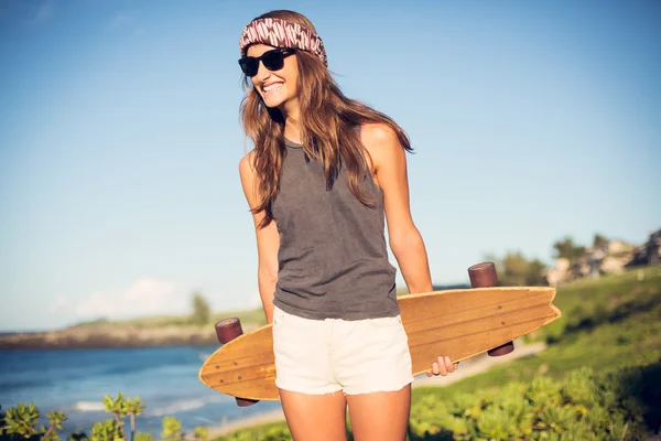 Hermosa joven con un monopatín — Foto de Stock