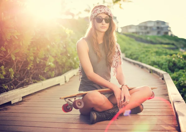 Hermosa joven con un monopatín — Foto de Stock