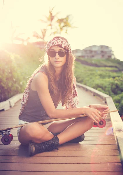 Красива молода жінка позує зі скейтбордом — стокове фото