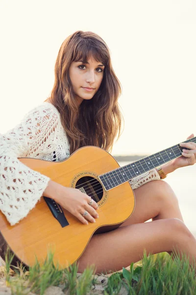 Beautiful young woman playing guitar on beach — Stock Photo, Image