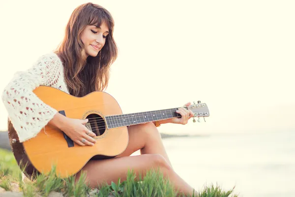 Belle jeune femme jouant de la guitare sur la plage — Photo