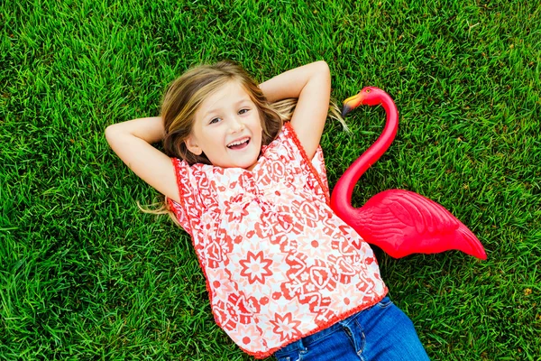 Girl lying on green grass Stock Photo