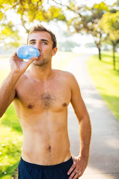 Atletico giovane uomo che beve acqua dopo l'allenamento — Foto Stock