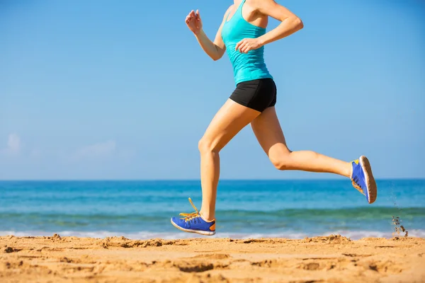 Vrouw loopt op het strand Stockfoto