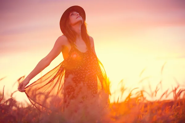 Mulher no campo dourado ao pôr do sol — Fotografia de Stock