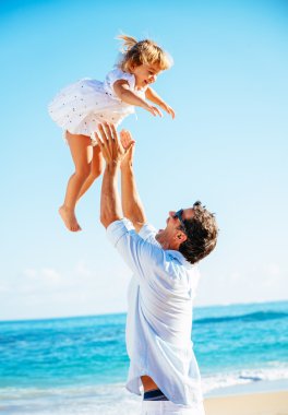 Baba ve kızı birlikte sahilde oynarken 