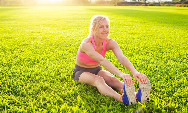 Atletische vrouw die zich uitstrekt — Stockfoto