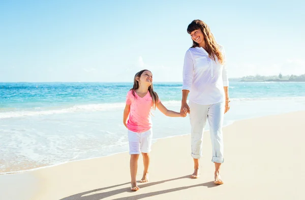 Happy mother and young daughter walking on the beach — Stock Photo, Image