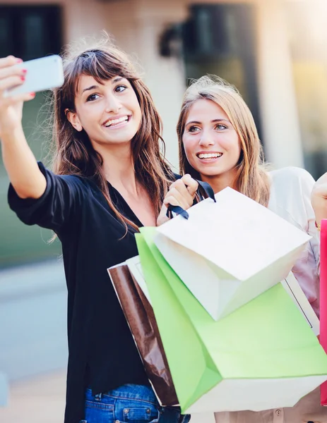 Meninas bonitas com sacos de compras tomar um "selfie " — Fotografia de Stock