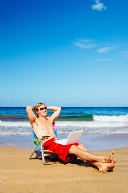 dizüstü bilgisayar ile plaj rahatlatıcı işadamı