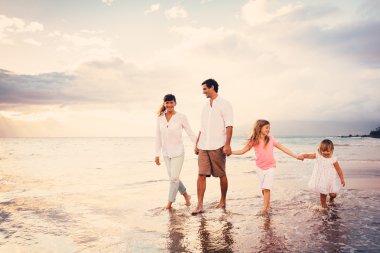 mutlu genç aile eğlenceli gün batımında sahilde yürüyüş