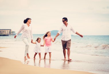 mutlu aile eğlenceli gün batımında sahilde yürüyüş