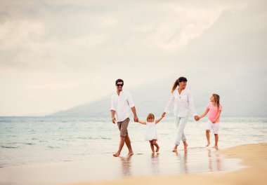mutlu aile eğlenceli gün batımında sahilde yürüyüş