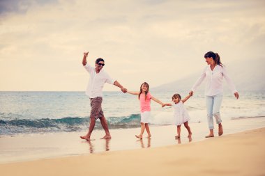 mutlu aile eğlenceli gün batımında sahilde yürüyüş