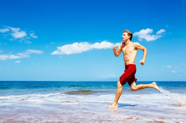 在海滩上跑步的运动员 — 图库照片