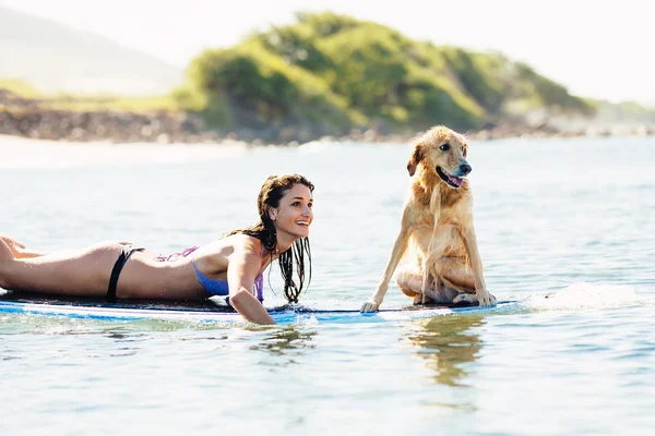 Młoda kobieta surfing z psem — Zdjęcie stockowe
